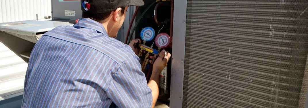 HVAC technician servicing a condenser unit in Murphy
